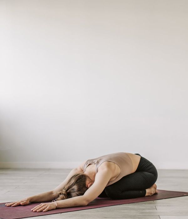 Person practicing yoga in a serene dark environment with mint lighting